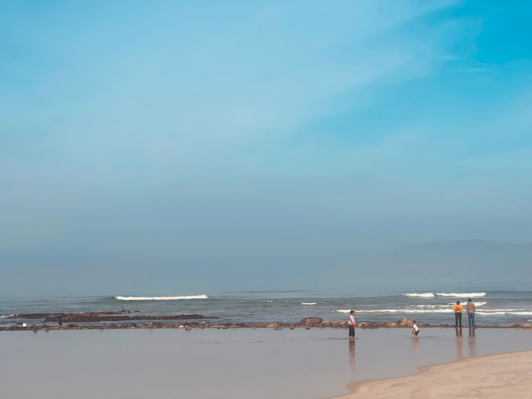 A quiet stretch of beach under a soft sky