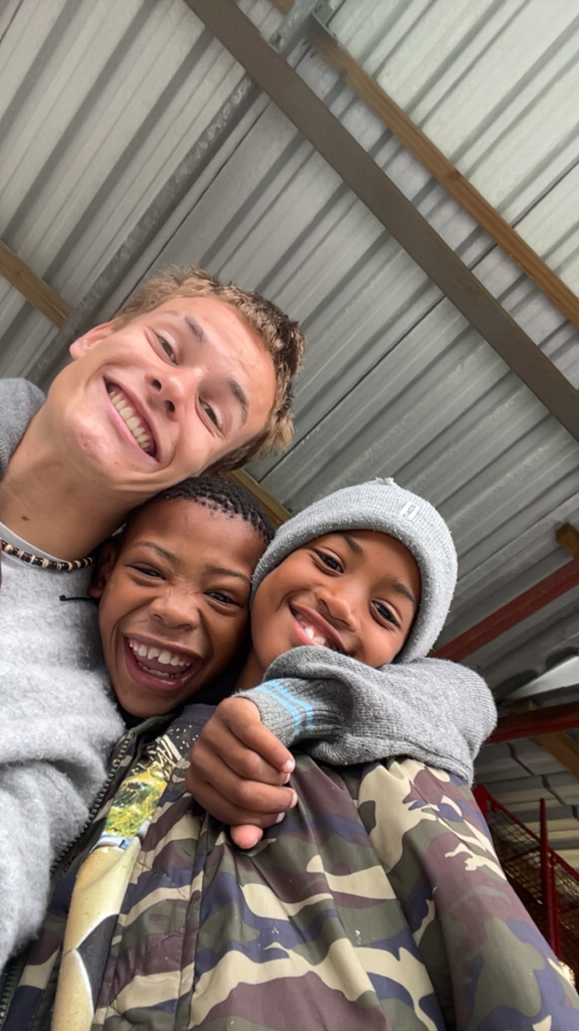 Three smiling faces crowded into a selfie